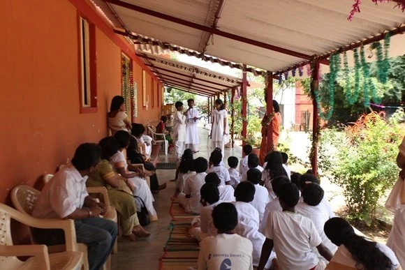 Gurukul kids singing and performing cultural dance in front of the gathered audience