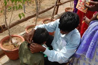 Parents tie the jeevan mukti mala (rosary) around the necks of their children.