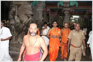 Swamiji escorted by the priest into the temple.
