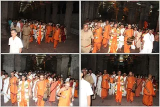 Swamiji walking the temple parikrama, accompanied by a large group of devotees.