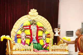 Arati to Devi as She stands nicely decorated in the day's Leela Alankara