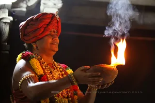 His Holiness places newly lit lamps around at the feet of the other Temple Deities.