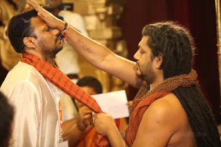 His Holiness energizes the Kavi scarves for participants during energy Darshan