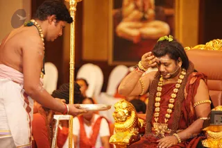 His Holiness applies sacred ash mixed with ghee from the Homa fire