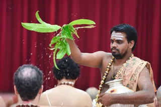 Prasada from the Kalasha Tirtha (water pot) is a blessing to have sprinkled on the delegates.