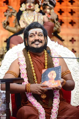 His Holiness holds the sacred text He gifted to the world 8 years ago!