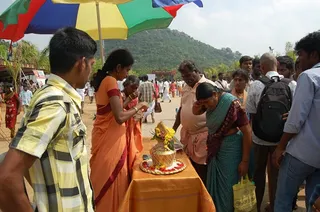 A brahmacharini welcomes the visitors with the traditional poorna kumbha (pot), vermillion and sandal paste