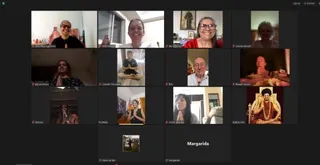 A screenshot of a video conference grid with thirteen tiles showing participants in home settings, most with palms pressed together in anjali mudra. Top-left, a woman in black with sunglasses sits before small figurines. Top-centre, a smiling woman in white. Top-right, a woman in a red top with a framed religious picture behind her. Middle row, a man in a white shirt sits cross-legged in meditation and a woman in a dark patterned top prays. Right, a person sits before a singing bowl. Bottom row includes a woman in a black top with hands joined, and a tile showing a seated figure in orange robes, ornate gold throne, and a garland-adorned mala, labelled Kailasa USA. Tile names include Vera Silva Aggiornho, Ila Oliveira, Joanne Garnett, Bob, Raquel Velasco, Lisandro Escalante, Pushkala, Lalita Gabriela and Margarida. Small thumbnail images show a seated figure and a group photo. Participants are visible only on screens.
