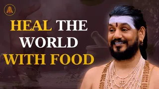 A promotional graphic with bold headline text reading HEAL THE WORLD WITH FOOD on a dark, muted background showing a blurred hand and a stone mortar with pestle. On the right, a smiling man with a white forehead band, red bindi, long swept-back dark hair, full beard, gold earring and multiple strands of pearl and gold-bead necklaces, bare-shouldered, appears in a cut-out photograph. A small circular temple emblem sits at the top left corner.