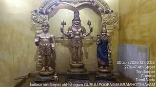 A photograph of a temple shrine niche with three bronze-toned standing deity murtis under an ornate golden arch decorated with flower garlands in red, white and blue. The central four-armed murti holds objects in its upper hands and stands on a lotus-style pedestal. A smaller murti stands on the left and a female murti in a dark blue garment stands on the right. A small figure sits on the floor at the lower left. No living people are visible. A timestamp reads 30 Jun 2025 12:50:02, with location text 278/47 4th Street, Tondiarpet, Chennai, Tamil Nadu. A caption reads kailasa tondiorpet abhishegam GURUU POORNIMA BRAMHOTSHAVAM.