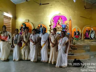 Six women in white and gold-bordered saris stand in a row in front of a shrine with golden walls and orange-backed niches holding deity murtis. The central murti, seated on a golden throne with a red crown and garlands, holds a trident and a kalasha-like object, and a sign on the shrine reads KAILASA Salem. Several women wear rudraksha malas and vibhuti or kumkum on their foreheads. Brass items sit on the steps in front of the shrine, and a sign at the right edge reads Salem. The image carries a timestamp of Apr 19, 2025 5:00:09 PM.