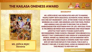 A graphic slide for the KAILASA Om Awards titled The KAILASA Oneness Award, with a gold and maroon design. On the left, a framed photo shows a woman in a white chef's jacket standing behind a buffet table of fruit, bowls and vegetarian dishes in a stone-walled restaurant. On the right, a block of biography text is printed in maroon on white, and a caption at the lower left names the honouree. Small emblem and deity-style icons appear in the top right corner, and a Vijayadasami label sits at the bottom right. The slide has no physical people in the scene beyond the printed photo.