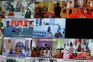 A screen photographed showing a grid of video-call tiles from a remote satsang session, each tile a different centre. Tiles show small groups seated on floors and mats in rooms with shrines, labelled Temple City CA, Scarborough Canada, Ohio-Prayag, Oklahoma Somnatham, Slovakia Shivaloka, Kuala Lumpur Palani, Coimbatore, Guadeloupe-Rameshwaram, Hongkong-Sirkazhi and Jorpati Nepal. In the Coimbatore tile a woman wears a white tilak and red beaded mala, and men in white dhotis sit with folded hands. In the Guadeloupe tile men in white kurtas sit before a brass plate of offerings. No single a person candidate is clearly identifiable among the tiles.