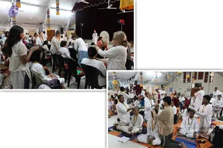 A two-panel collage of photographs from a hall with white tent-like ceiling, hanging orange and yellow banners and fans. Left panel: a woman in white clothes stands beside seated people in white, one seated figure's head being touched by a woman in white; a standing figure in white is far off near a stage. Right panel: a man in a tan shirt pours or applies something on the head of a seated person in white with a garland; many people in white sit on orange mats with beaded garlands while others stand. Yellow banners and a stage with a backdrop are visible. No identifiable a person depiction is visible.
