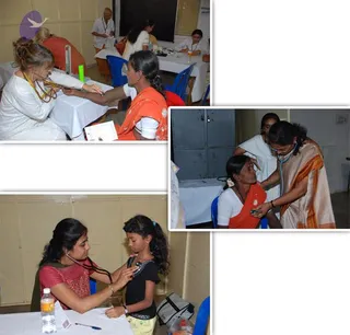 A three-panel collage of photographs from a free medical camp. Top left: a woman in white clothes with a stethoscope examines a woman in an orange sari at a table with a white cloth and a blue chair, another medical staffer in white works in the background. Right: a woman in a white top and a woman in a cream-and-orange sari use a stethoscope on an older woman in an orange sari and white blouse, seated on a blue chair beside grey lockers. Bottom left: a doctor in a maroon top with a stethoscope examines a young girl in a black top and yellow pants at a table with a water bottle and bag. The scene shows routine medical checkups.